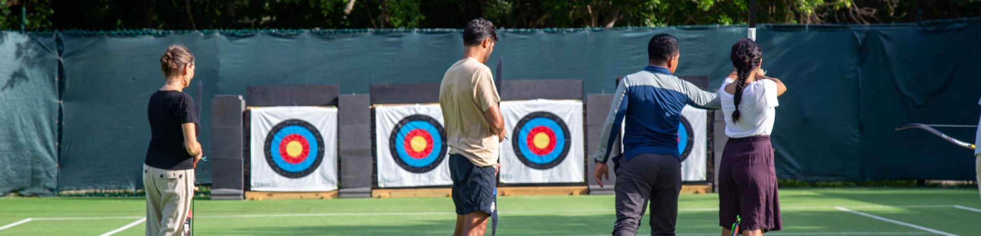 People practicing archery in an outdoor court.