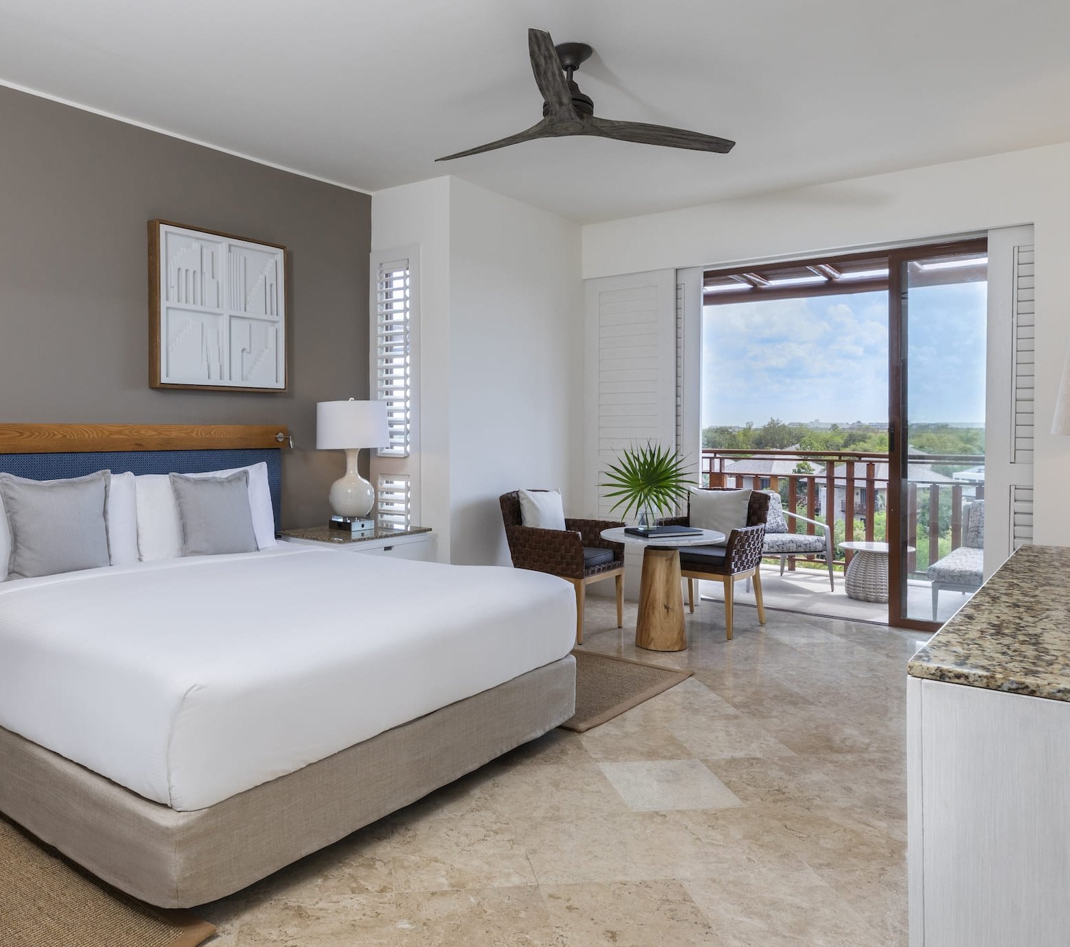 The bed and outdoor terrace in a Fairmont Mayakoba guest room.