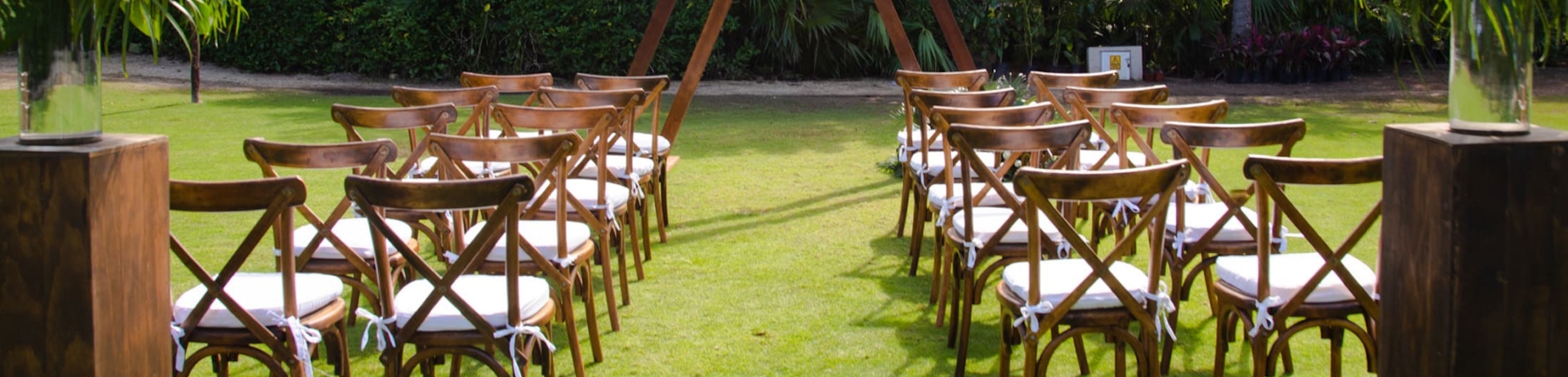 An outdoor wedding aisle and archway set on a manicured lawn.