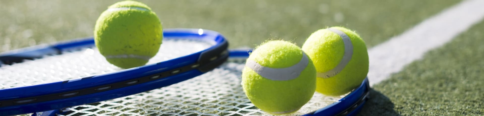 Tennis rackets and balls on an astroturf court