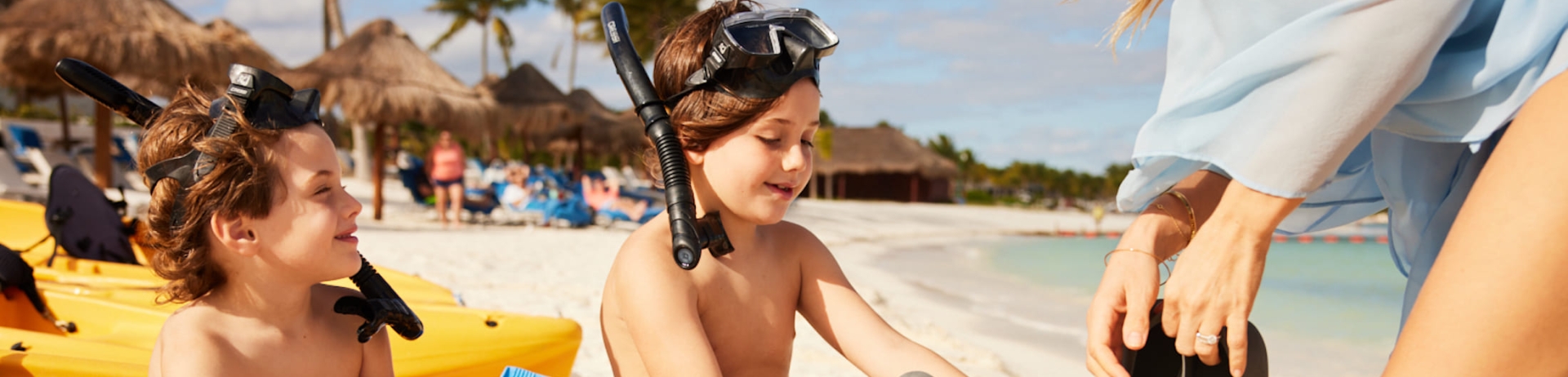 Kids putting on flippers to go snorkling